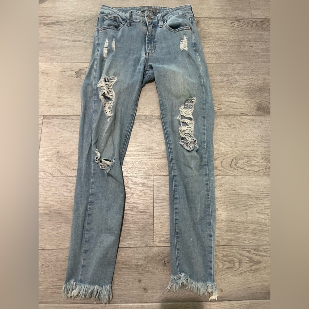 Light wash distressed skinny jeans with frey bottom